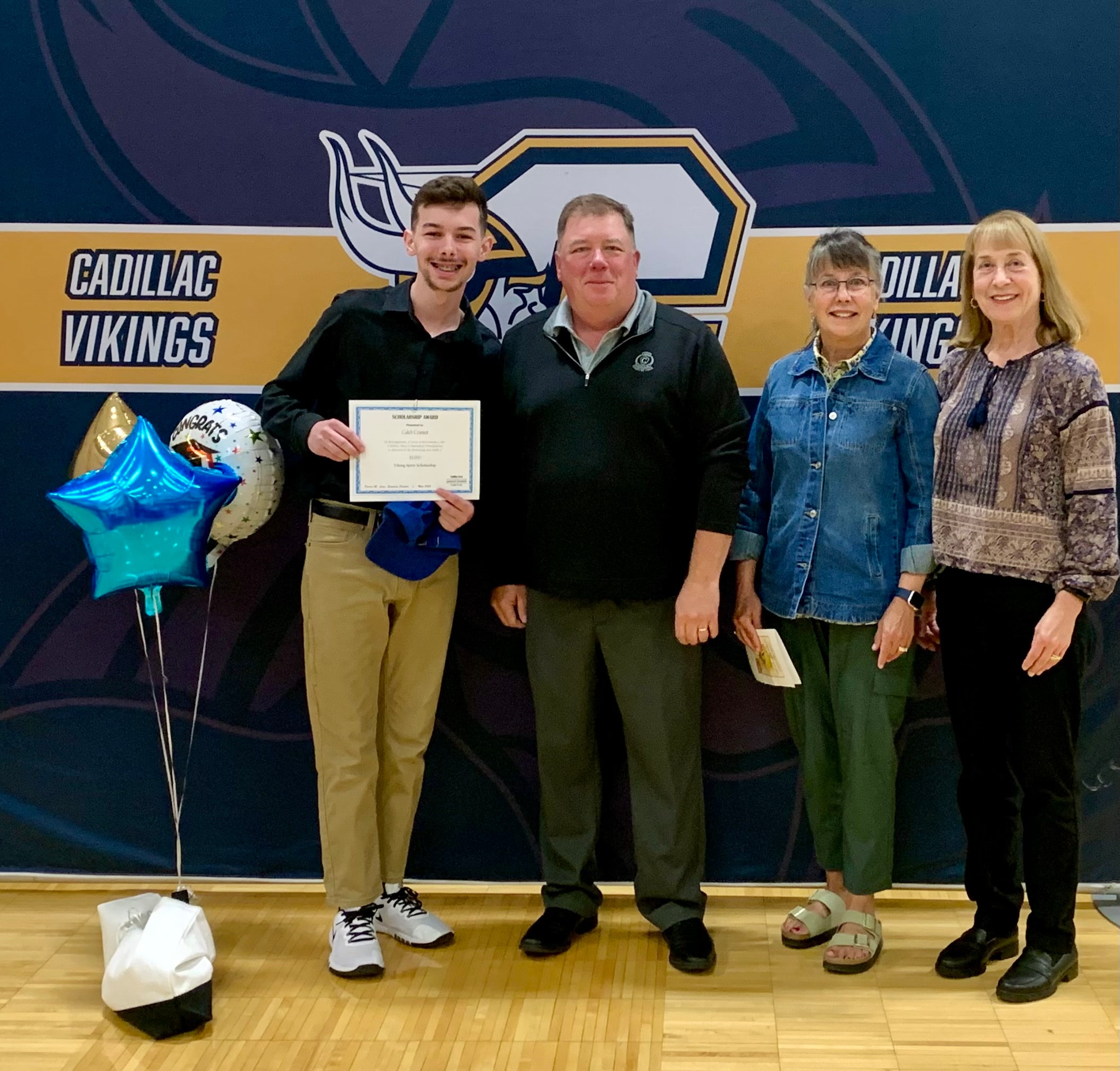 Caleb Cramer, inaugural Viking Alumni Spirit Scholarship recipient, with committee members at Cadillac High School